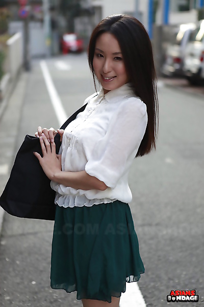 Japanese schoolgirl Anna Sakura pauses in the street to 